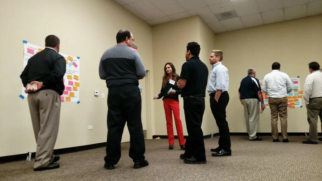 People organizing a program increment on brown paper posters with sticky posts